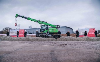 grüner Kran steht auf Baufläche