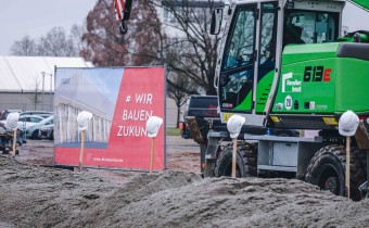 grüner Kran steht auf Baufläche